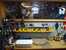 Pegboard panel with assorted hand tools hung in a garage workshop