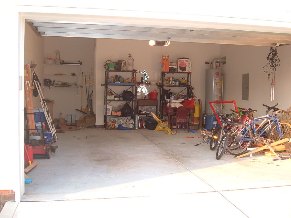 A cluttered garage filled with boxes and miscellaneous items before cleanout